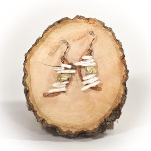 Handmade shell earrings on wooden slab.