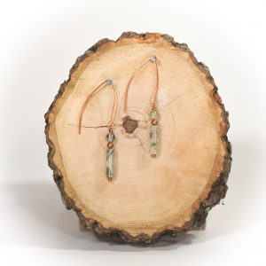 Handmade earrings on wooden slice display