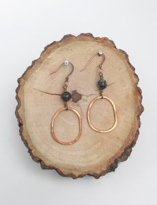 Copper hoop earrings on wooden slab