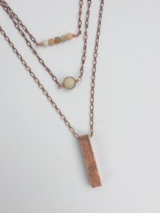 Layered copper and beaded pendant necklace on display