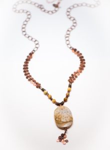 Rustic brass beaded necklace with stone pendant.