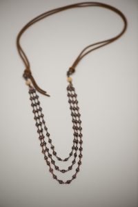 Brown beaded necklace on leather cord.