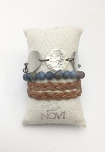 Leather and silver bead bracelet on cushion.