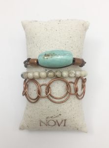Three bracelets on textured cream cushion.