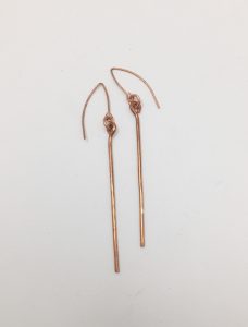 Simple copper wire earrings on white background.
