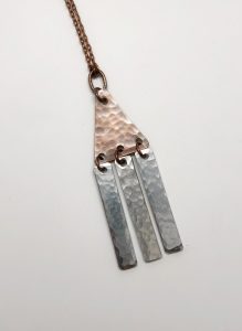 Handmade hammered metal necklace with triangular pendant.