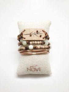 Boho beaded bracelet on fabric cushion.