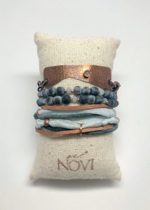 Copper and fabric bracelet on pillow display.