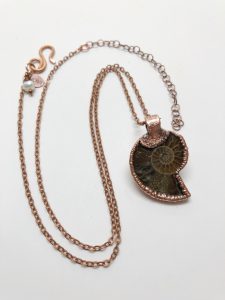 Copper chain necklace with fossil pendant.