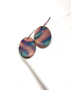 Colorful swirl oval earrings on white surface
