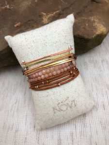 Stacked bracelets on fabric pillow display