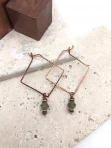Copper wire earrings with green beads on stone