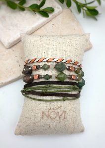 Handmade beaded bracelets on burlap pillow display.