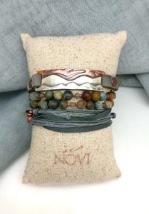 Stacked bracelets on a linen cushion.