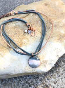 Handcrafted stone necklace on rustic background.