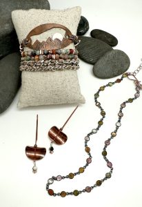 Handcrafted jewelry with stones, earrings, and bracelet.