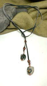 Pendant necklace with gemstone beads on fabric background