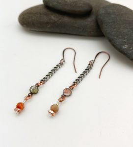Handmade gemstone earrings on white surface.