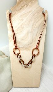 Brown and white chain necklace on display stand.