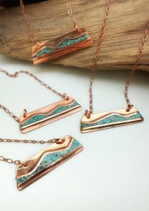 Copper and turquoise gemstone bar necklaces on display