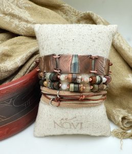 Handcrafted beaded bracelets on display with fabric backdrop.